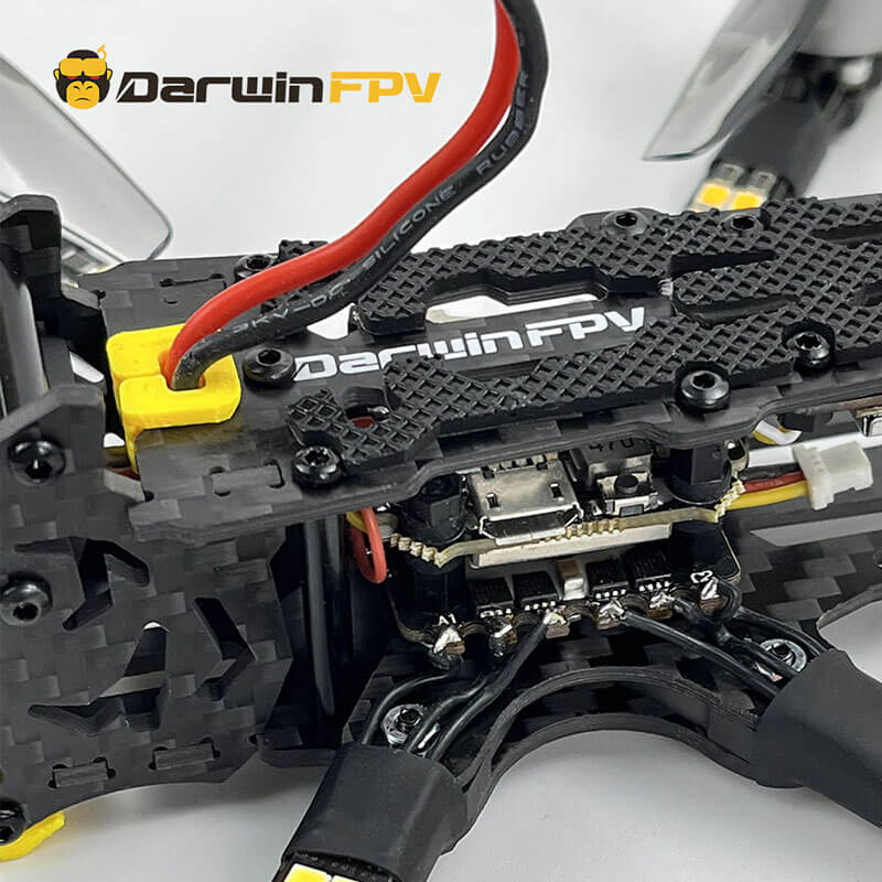Detailed close-up of DarwinFPV drone with focus on wiring, power connector, and carbon fiber frame