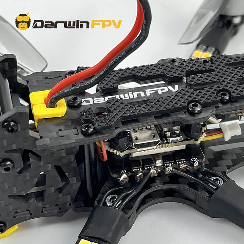 Detailed close-up of DarwinFPV drone with focus on wiring, power connector, and carbon fiber frame