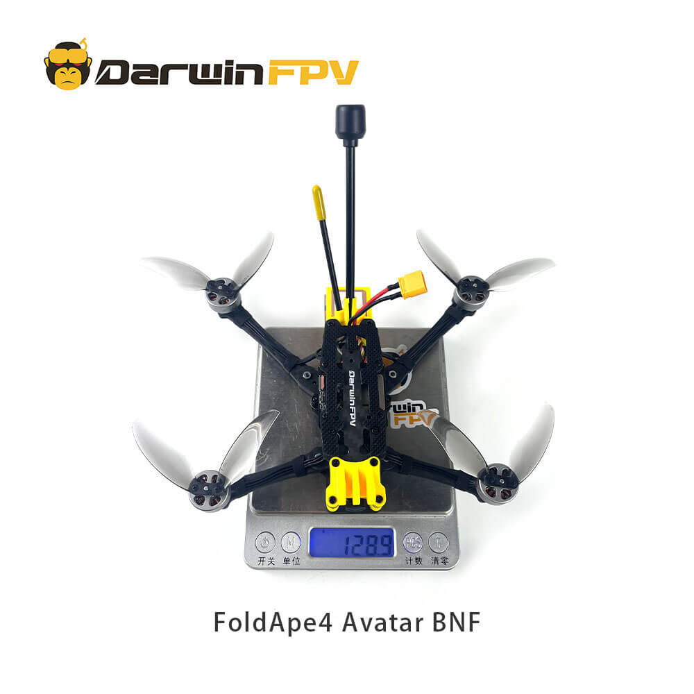 Top-down view of the DarwinFPV FoldApe4 Avatar BNF drone placed on a digital scale, displaying a weight of 128.9 grams, with its frame and folded arms clearly visible.