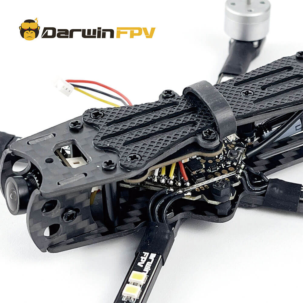 Detailed close-up of the DarwinFPV BabyApe drone showing the carbon fiber frame, exposed internal circuitry, and mounted camera, highlighting the compact and efficient design of the FPV drone